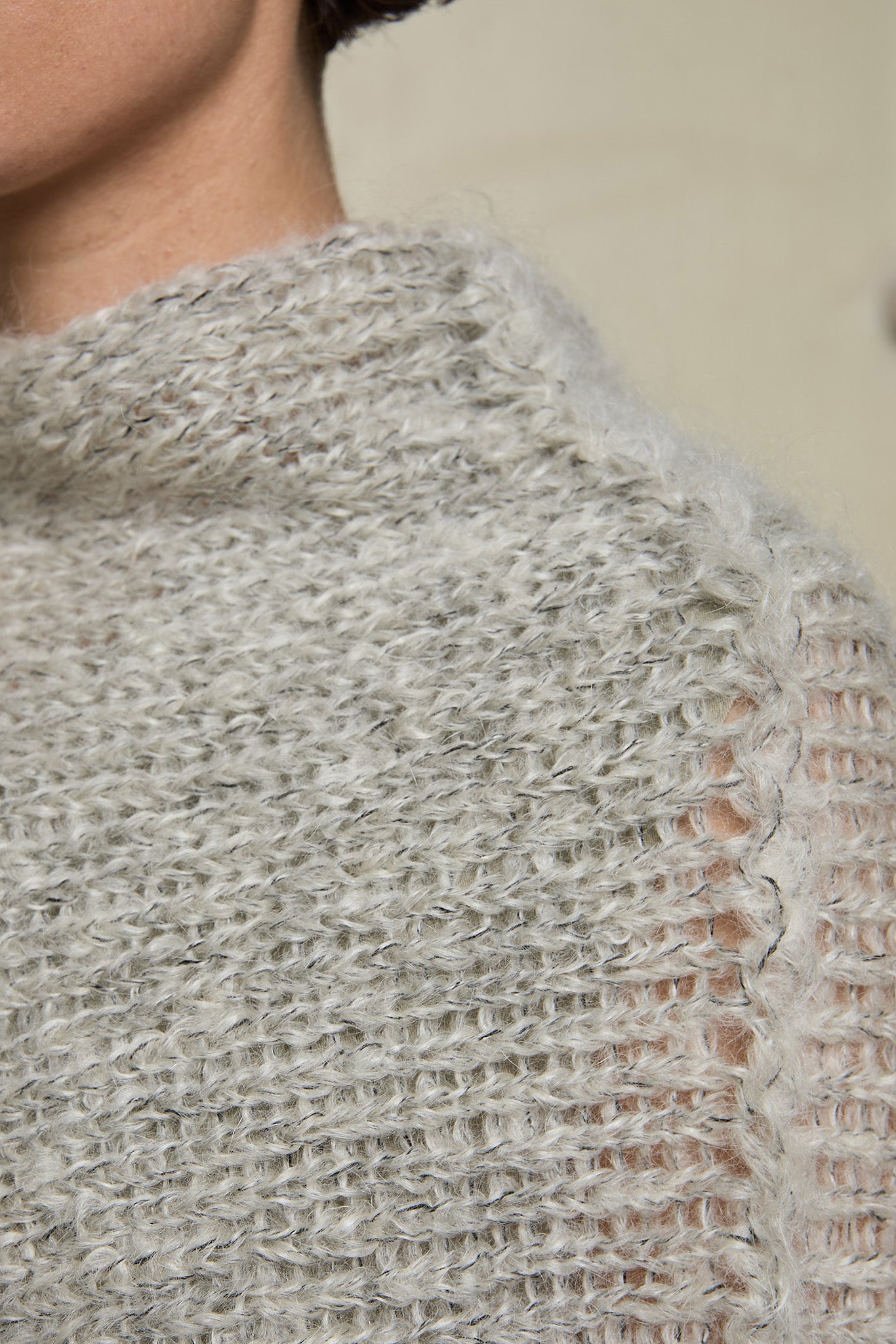 Close up fabric view of mohair cocoon, an asymmetric poncho in a white flecked colourway