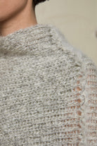 Close up fabric view of mohair cocoon, an asymmetric poncho in a white flecked colourway