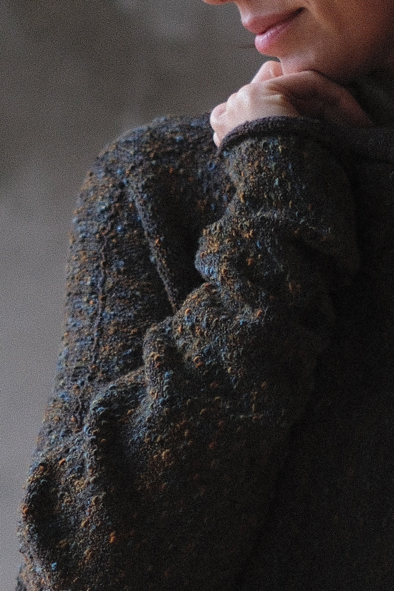 Close-up of a textured brown sweater with a blurred background
