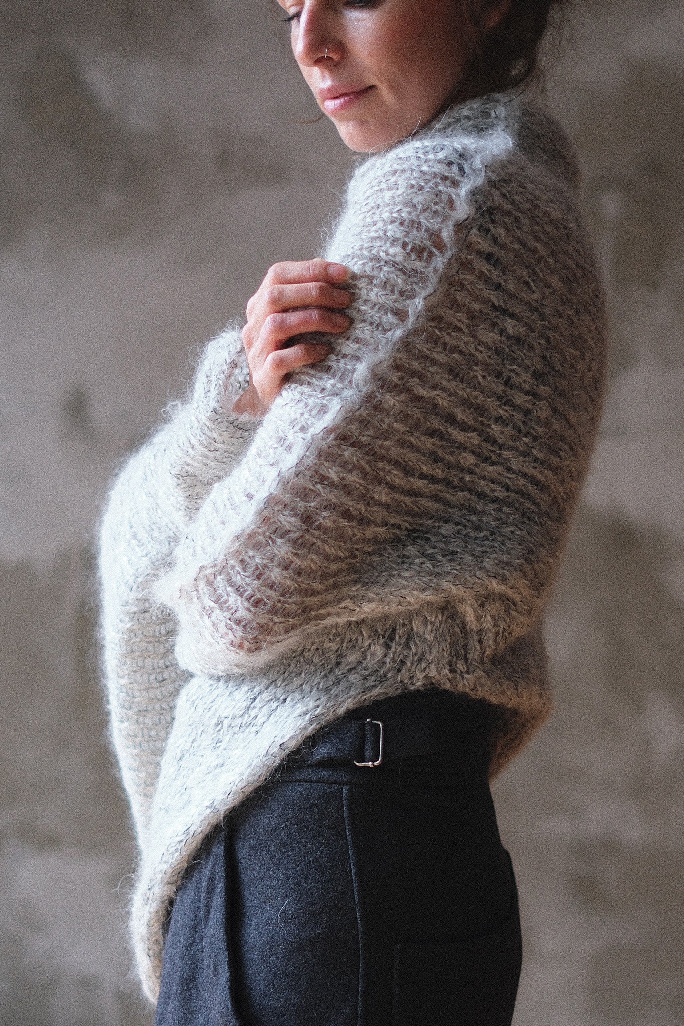 Model wears a mohair cocoon sleeved jumper in a natural colour.