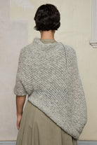 Back view of model wearing mohair cocoon, an asymmetric poncho in a white flecked colourway