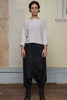 Front view of model wearing a knitted natural coloured batwing, designed and knitted in Melbourne by Wendy Voon knits