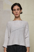 Front view of model wearing a natural coloured knitted batwing, designed and knitted in Melbourne by Wendy Voon knits