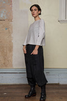 Front view of model wearing a knitted natural coloured batwing, designed and knitted in Melbourne by Wendy Voon knits