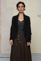 Model wears a knitted shawl collared cardigan iunfastenned in a black colourway.  Cardigan is designed and knitted in  Melbourne by Wendy Voon knits.
