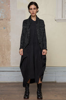 Model wears black and white flecked knitted shawl collared cardigan.