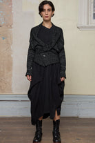 Model wears black and white flecked knitted shawl collared cardi belted.
