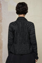 Back view of model wearing a black with white flecks shawl collared cardigan upside down.