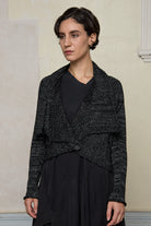 Model wears a black with white flecks shawl collared cardigan upside down, and is cinched at the waist with a safety pin.