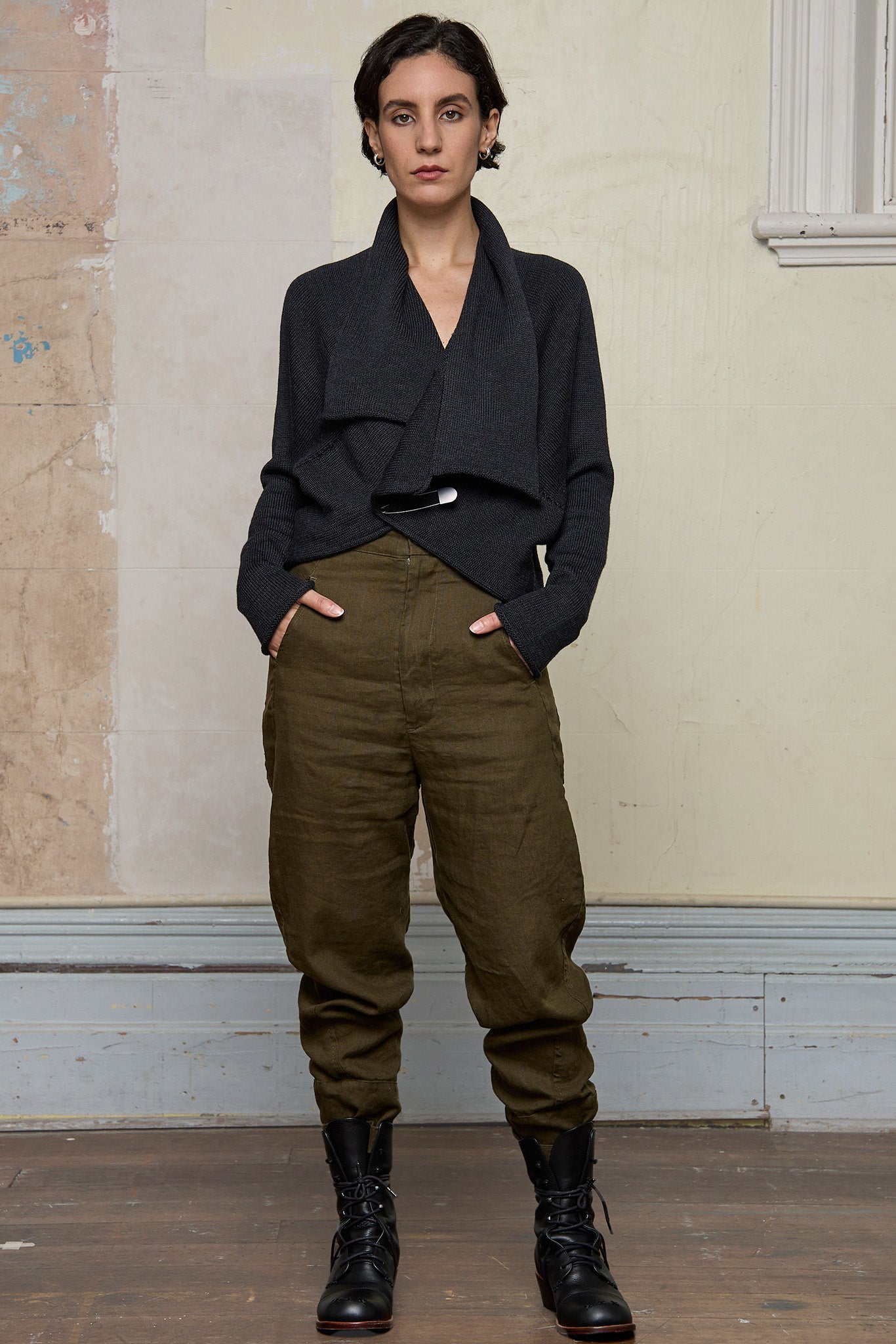 Model wears a knitted shawl collared cardigan upside down and pinned at the waist in a charcoal colourway.  Cardigan is designed and knitted in  Melbourne by Wendy Voon knits.