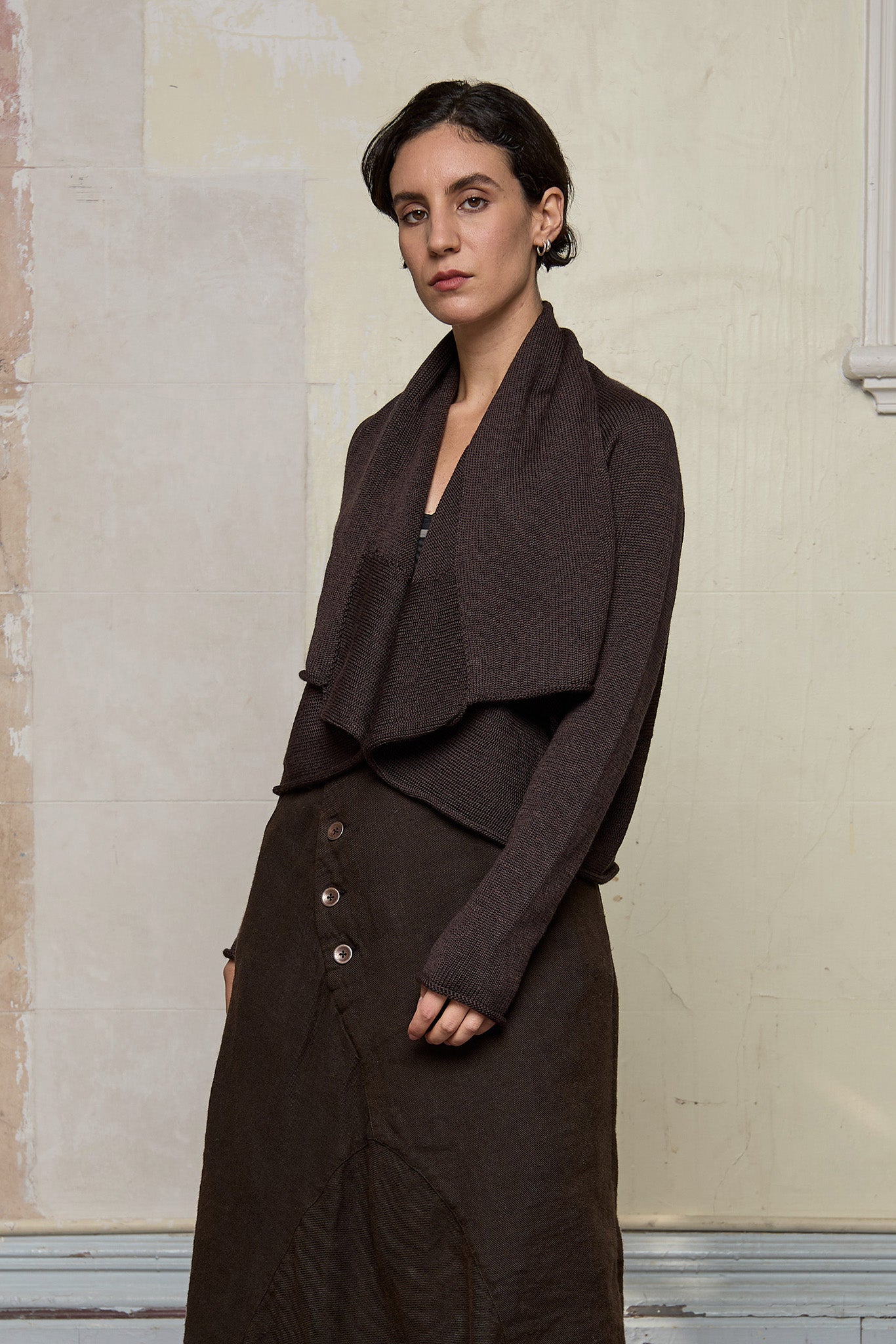 Model wears a knitted shawl collared cardigan upside down in a chocolate brown colourway.  Cardigan is designed and knitted in  Melbourne by Wendy Voon knits.