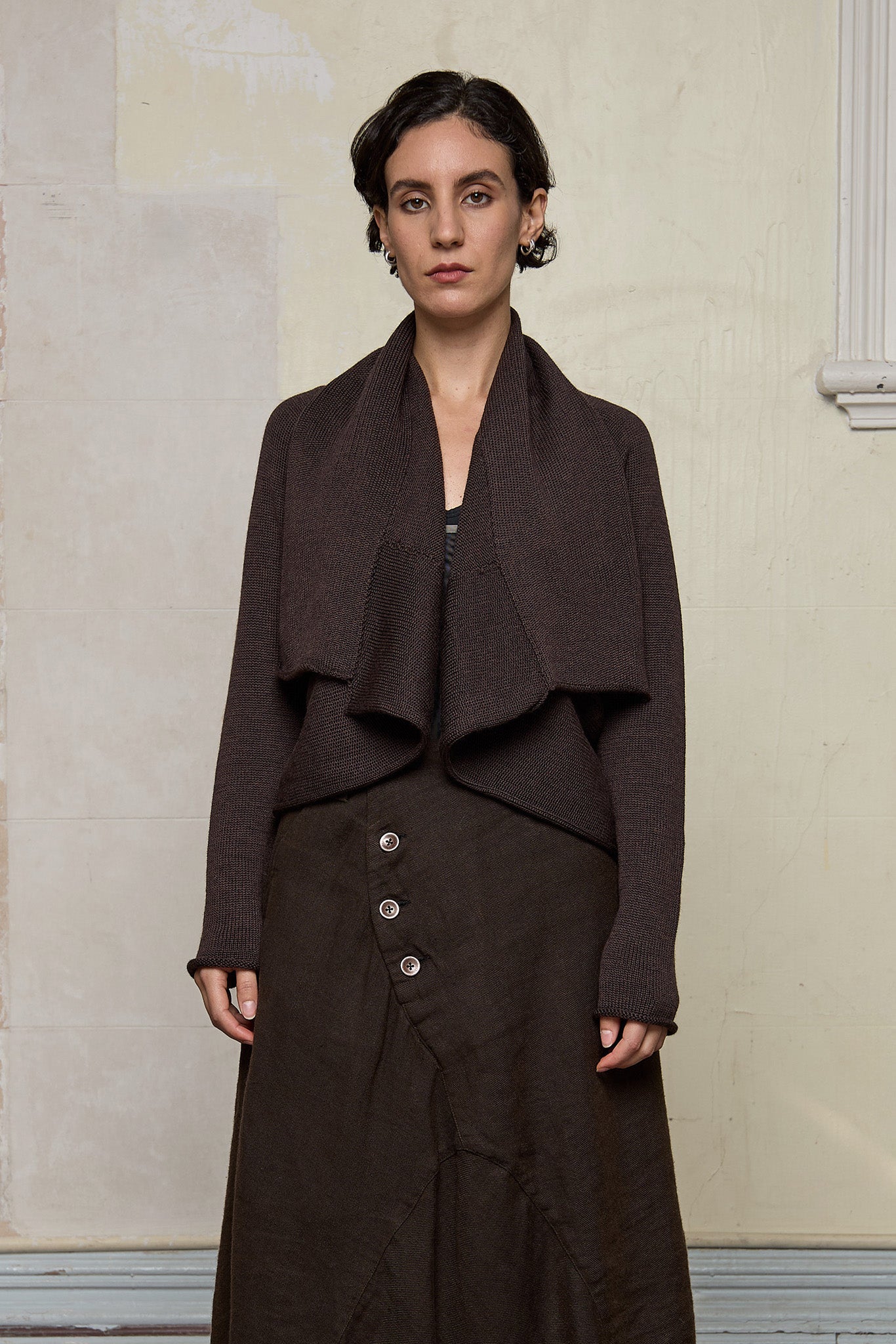 Model wears a knitted shawl collared cardigan upside down in a chocolate brown colourway.  Cardigan is designed and knitted in  Melbourne by Wendy Voon knits.
