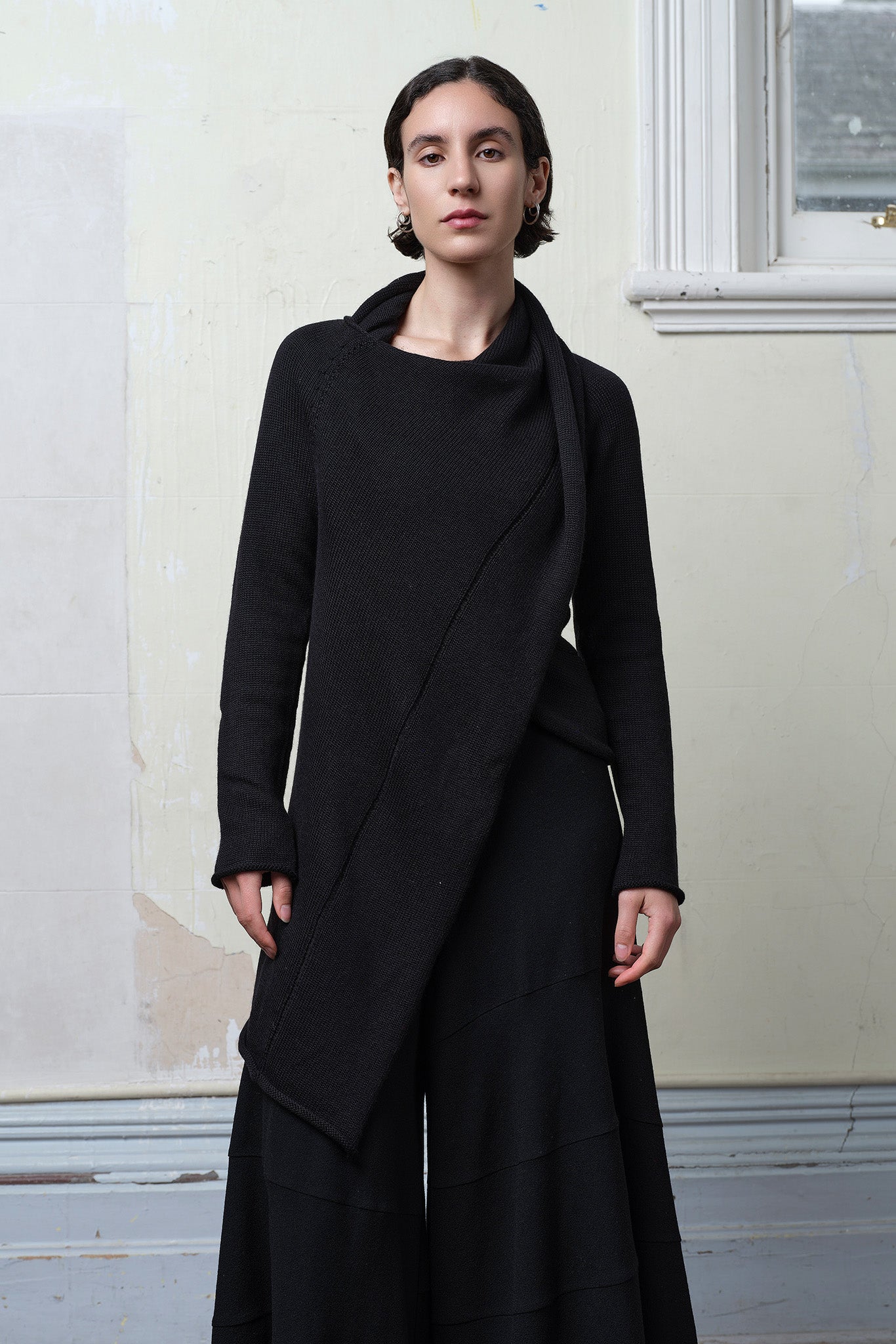 Model wears knitted merino cross over, in black colourway.