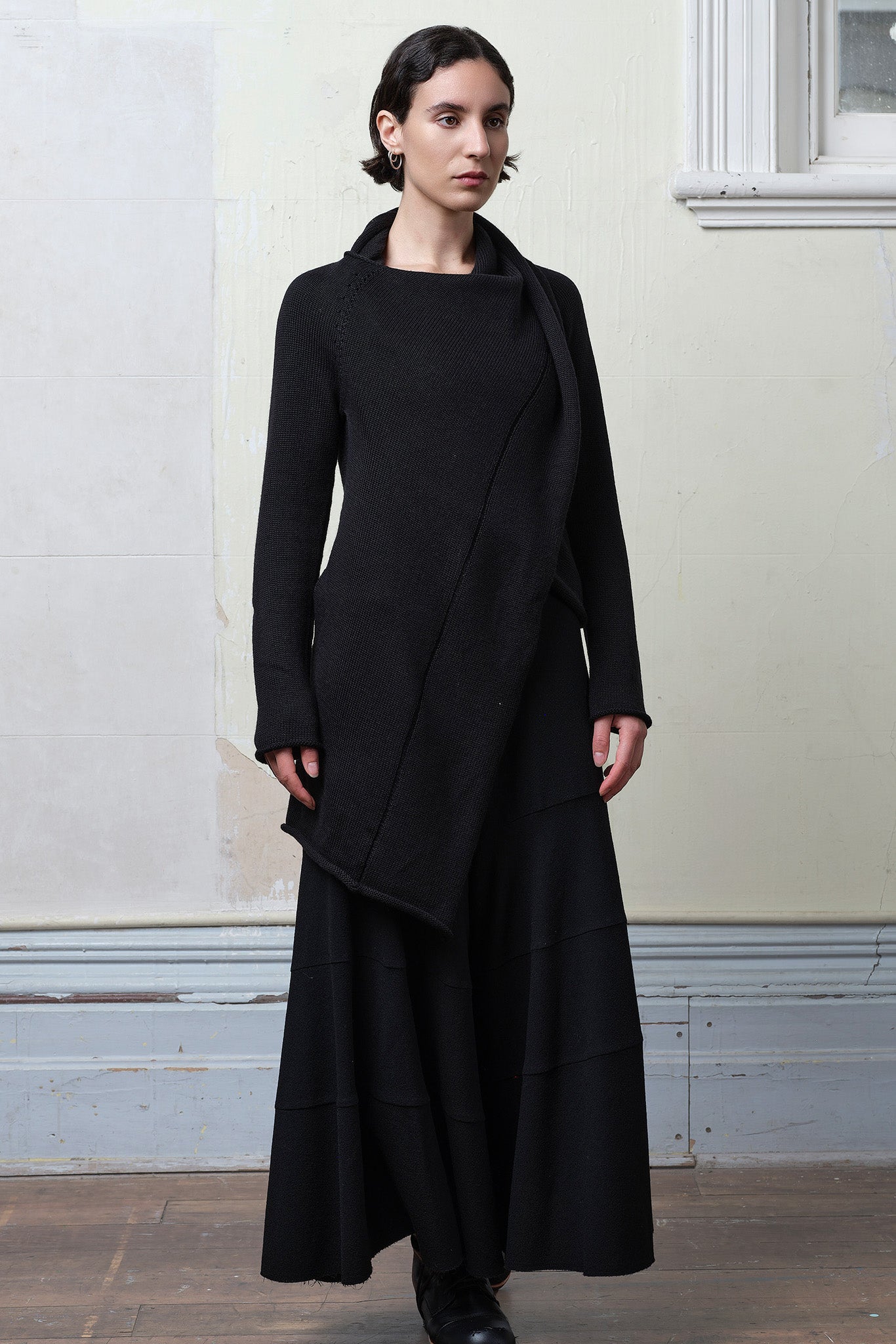 Model wears knitted merino cross over, in black colourway.