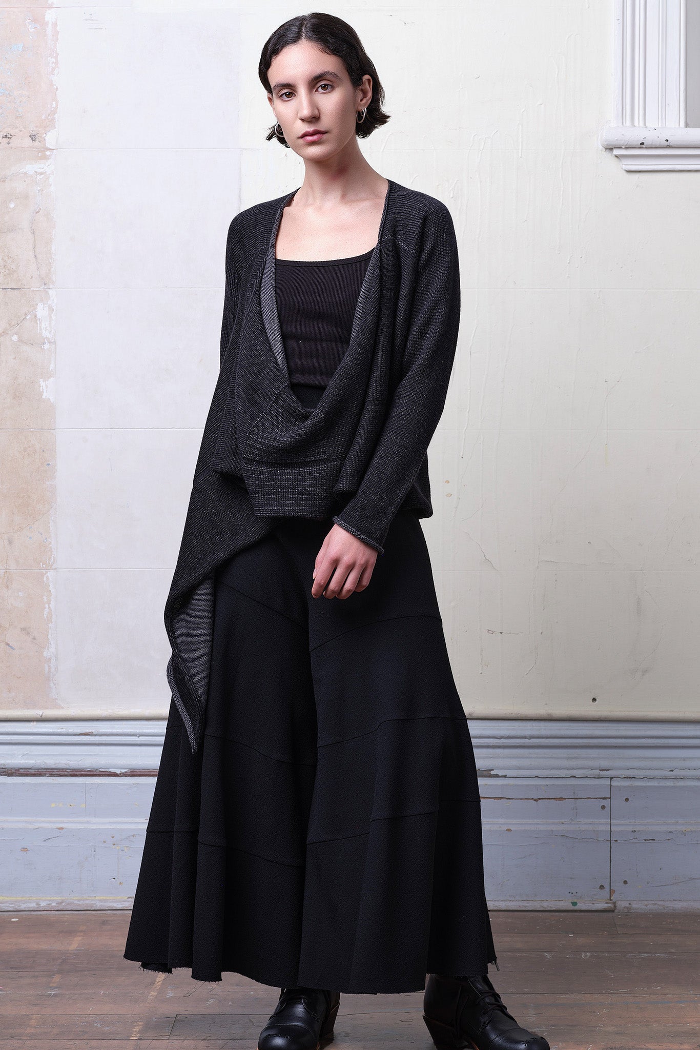 Model wears knitted merino cross over, undone in black and charcoal colourway.