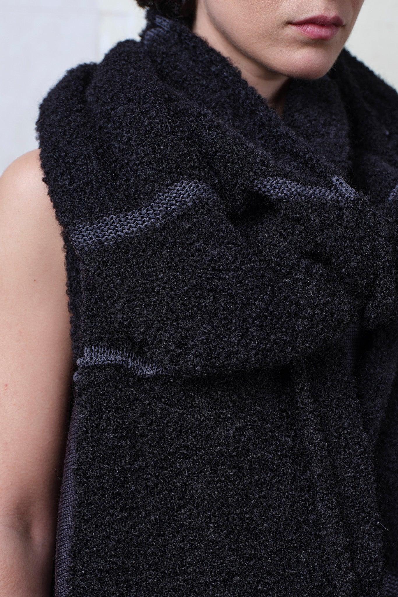 Close up view of knitted black alpaca wrap with contrasting slate cotton stripes