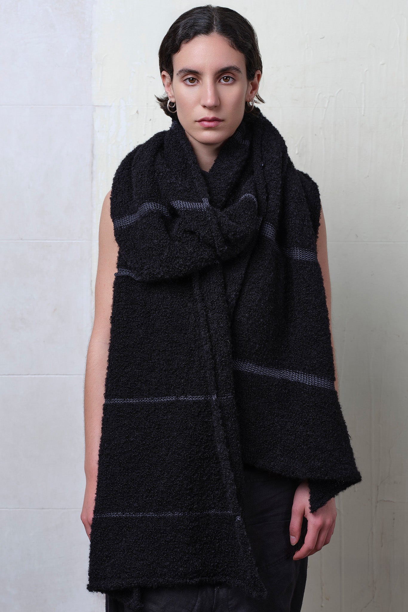 Model wears knitted black alpaca wrap with contrasting slate cotton stripes