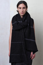 Model wears knitted black alpaca wrap with contrasting slate cotton stripes