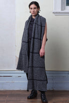 Model wears knitted alpaca wrap in storm grey with contrasting slate cotton stripes.
