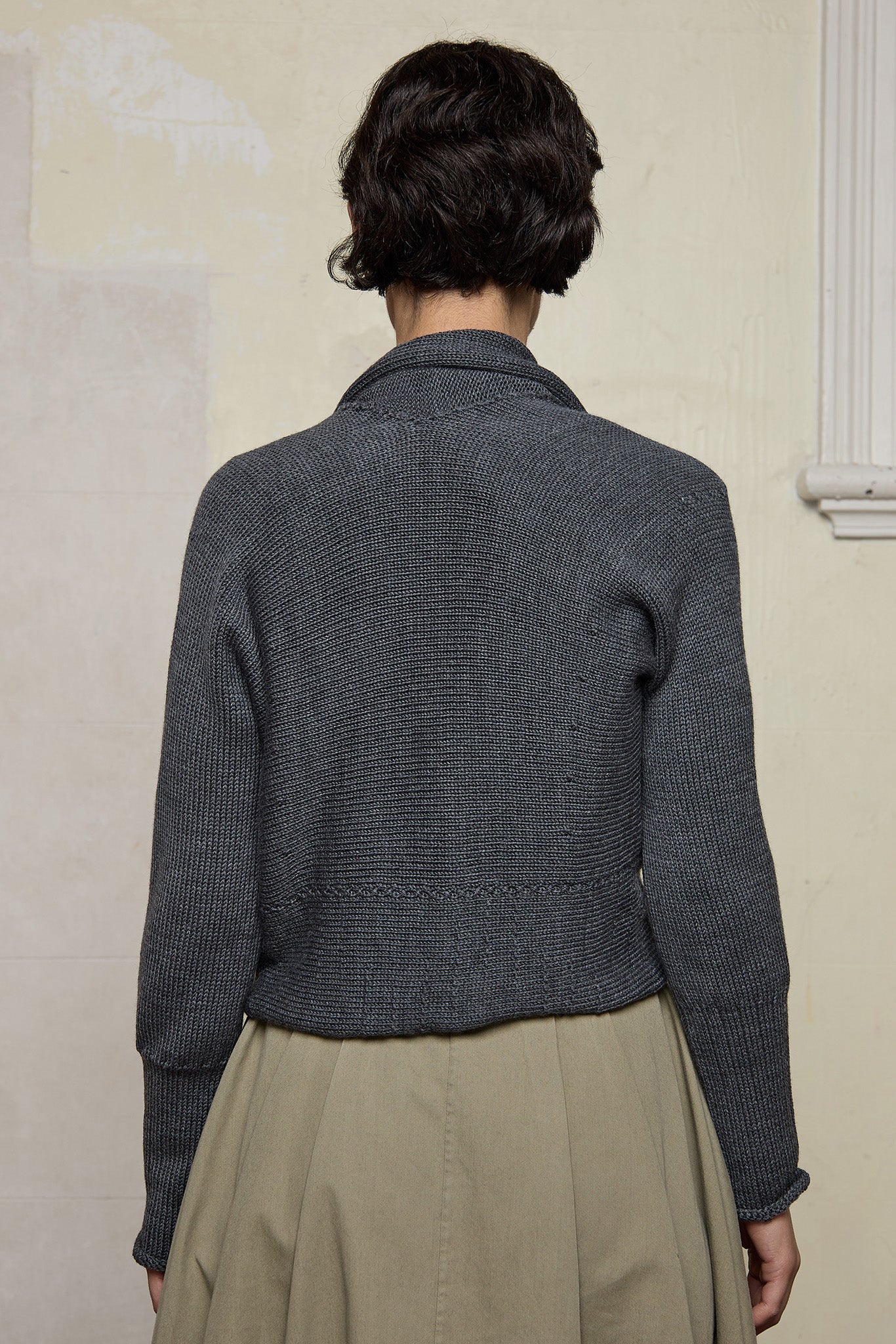Back view of Chunky Knit Cardigan design by Wendy Voon in steel grey superfine merino wool with black buttons.