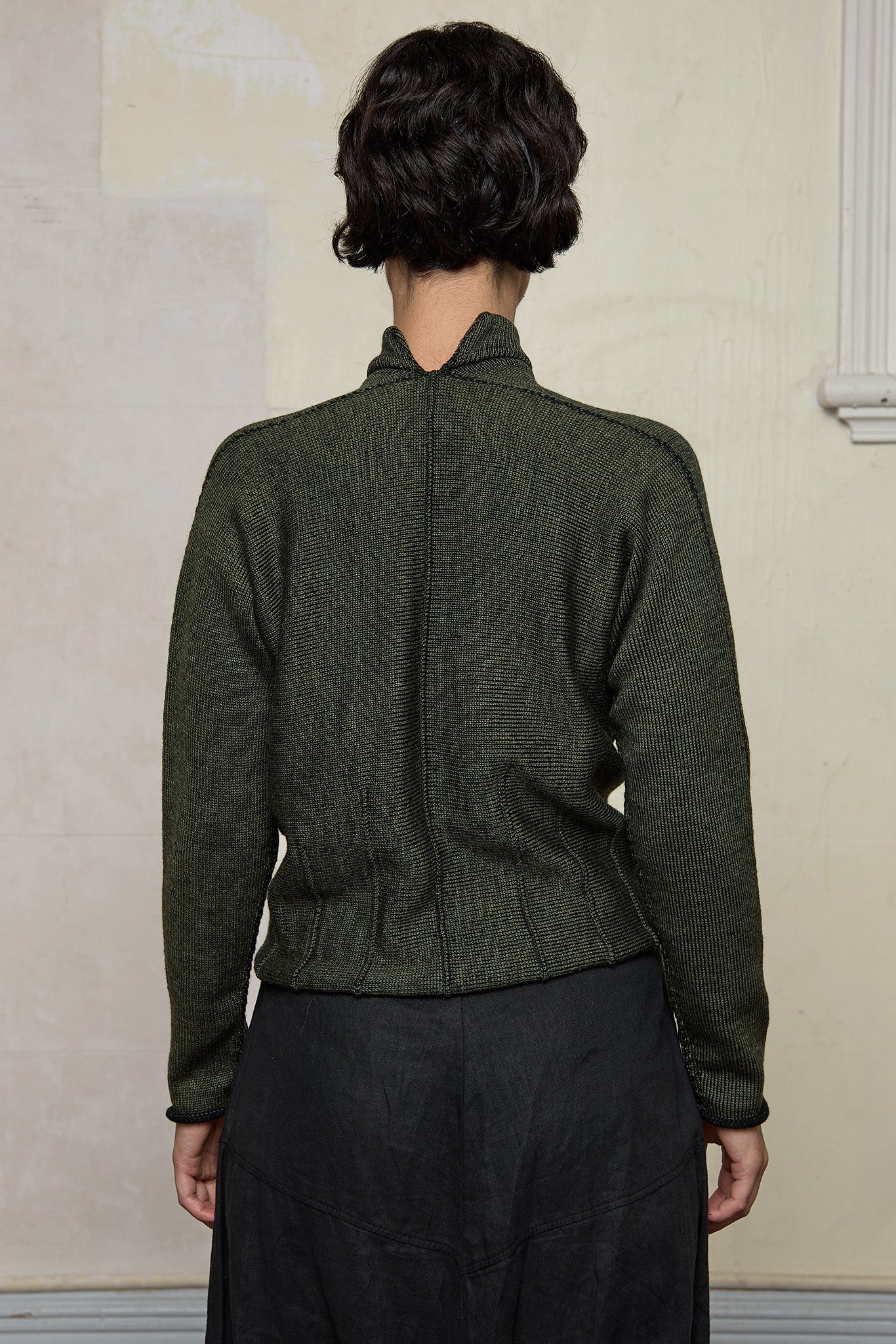 Back view of model wearing welted wool cardigan in army backed with black colourway. Designed and made in Melbourne by Wendy Voon knits.