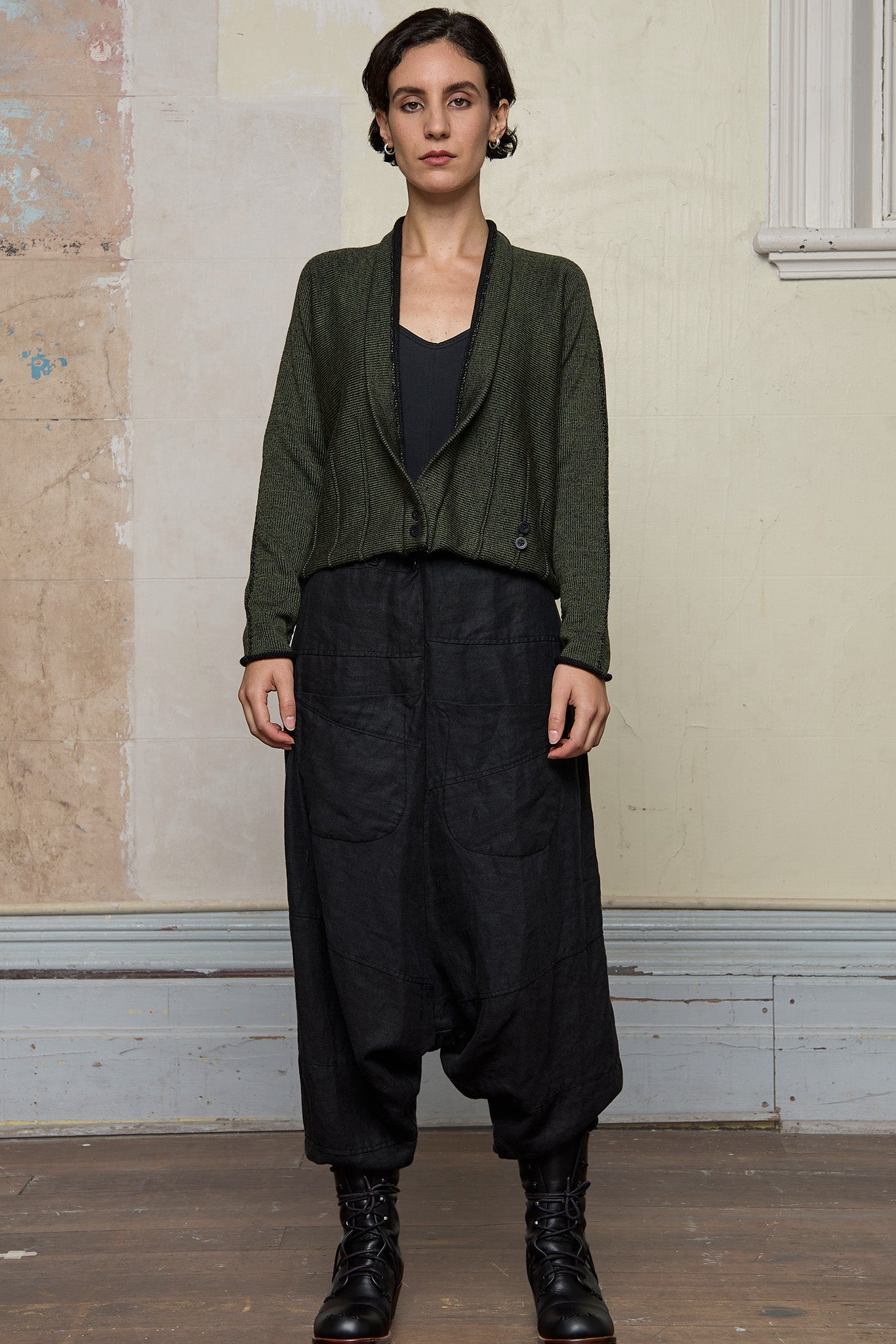 Model wears welted wool cardigan buttoned up in army backed with black colourway. Designed and made in Melbourne by Wendy Voon knits.