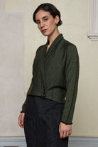 Model wears welted wool cardigan buttoned up in army backed with black colourway. Designed and made in Melbourne by Wendy Voon knits.