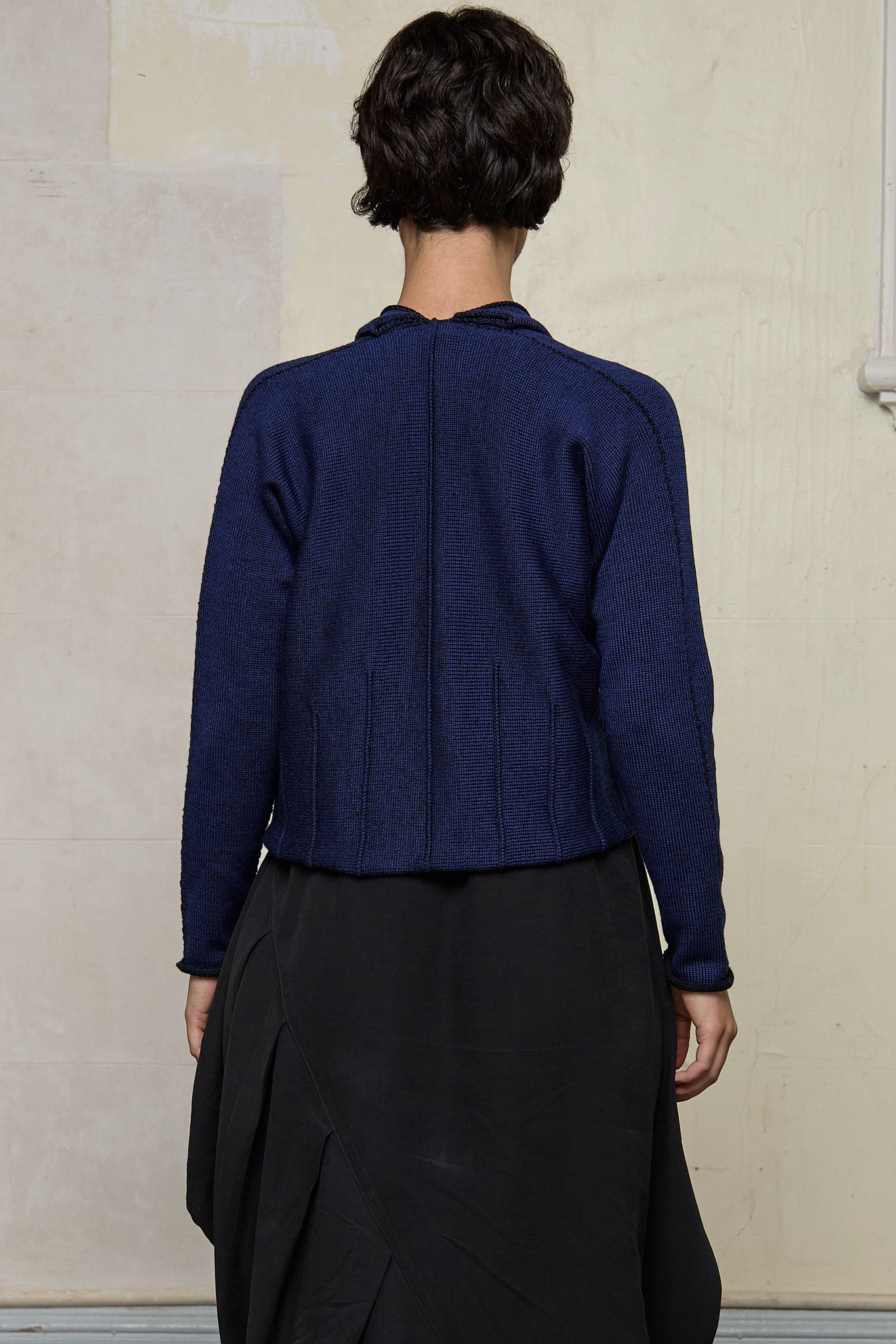 Back view of model wearing welted wool cardigan in blue backed with black colourway. Designed and made in Melbourne by Wendy Voon knits.