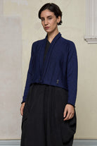 Model wears welted wool cardigan buttoned up in blue backed with black colourway. Designed and made in Melbourne by Wendy Voon knits.