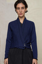 Model wears welted wool cardigan buttoned up in blue backed with black colourway. Designed and made in Melbourne by Wendy Voon knits.