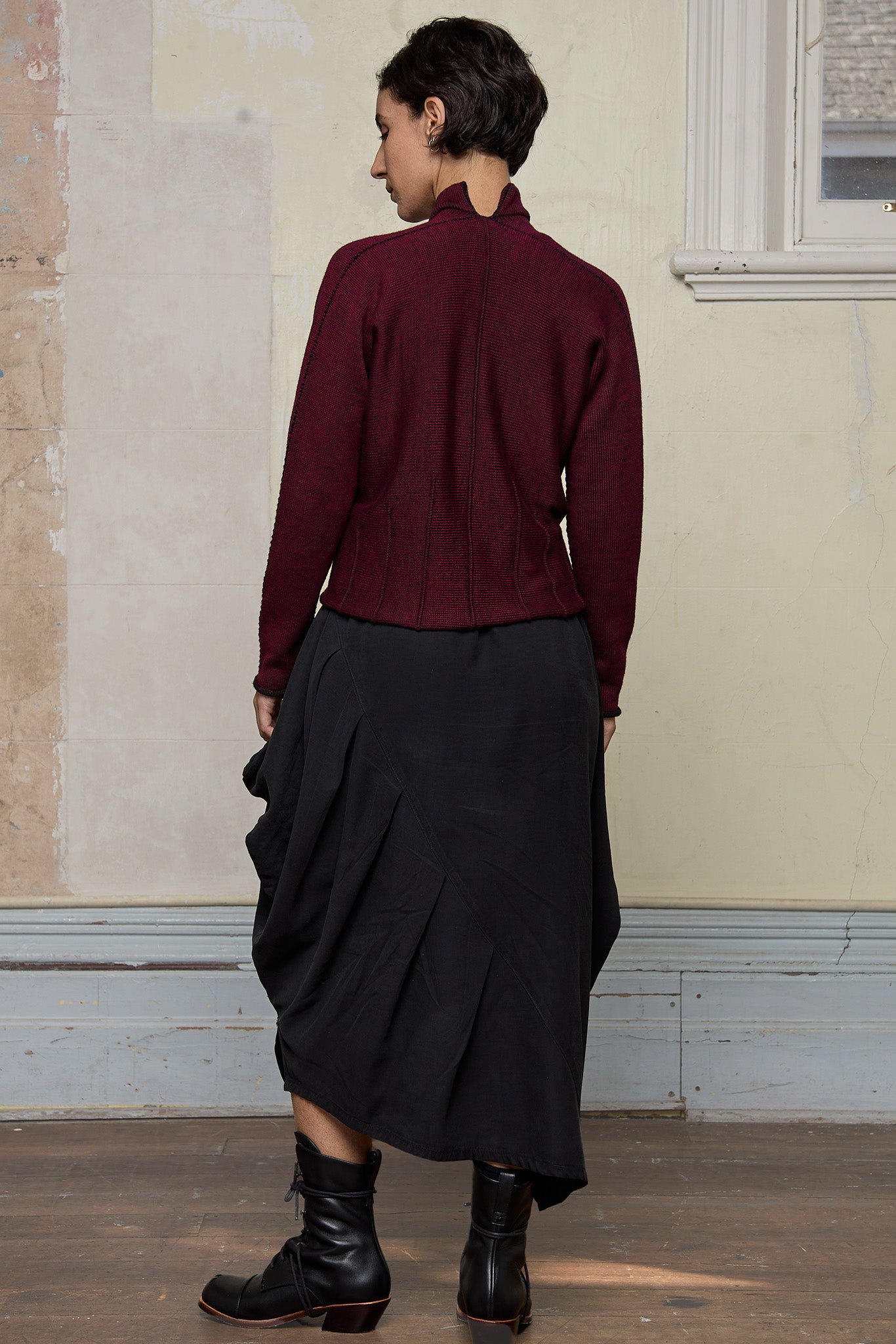 Back view of model wearing a welted wool cardigan in burgundy backed with black colourway. Designed and made in Melbourne by Wendy Voon knits.