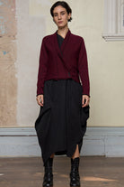 Model wears welted wool cardigan buttoned up in burgundy backed with black colourway. Designed and made in Melbourne by Wendy Voon knits.