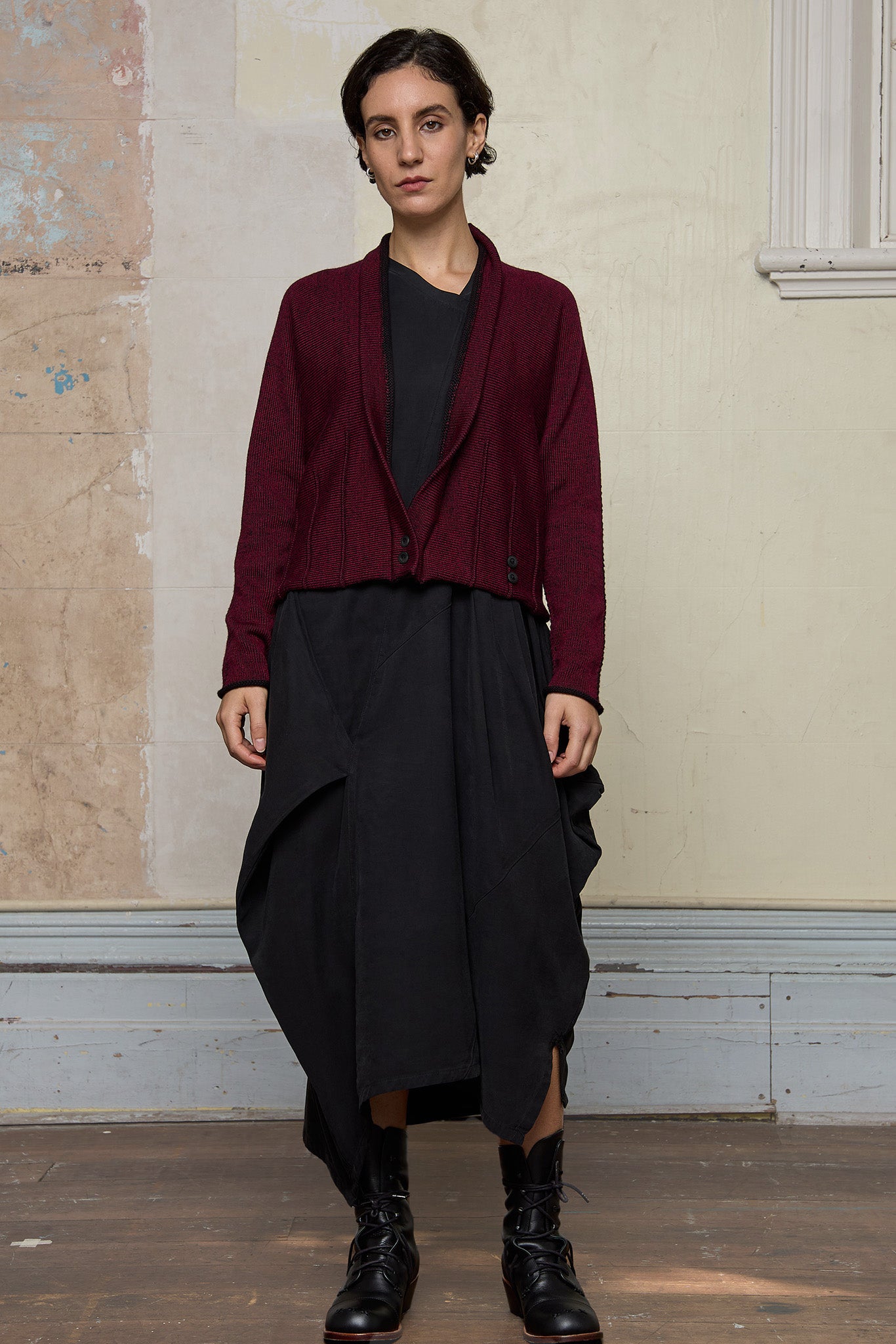 Model wears welted wool cardigan buttoned up in burgundy backed with black colourway. Designed and made in Melbourne by Wendy Voon knits.