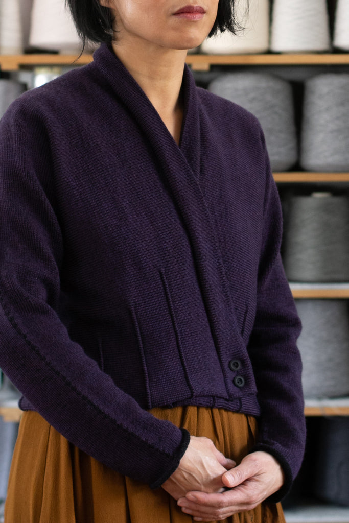 Front view of welted wool cardigan buttoned up in eggplant/black colourway