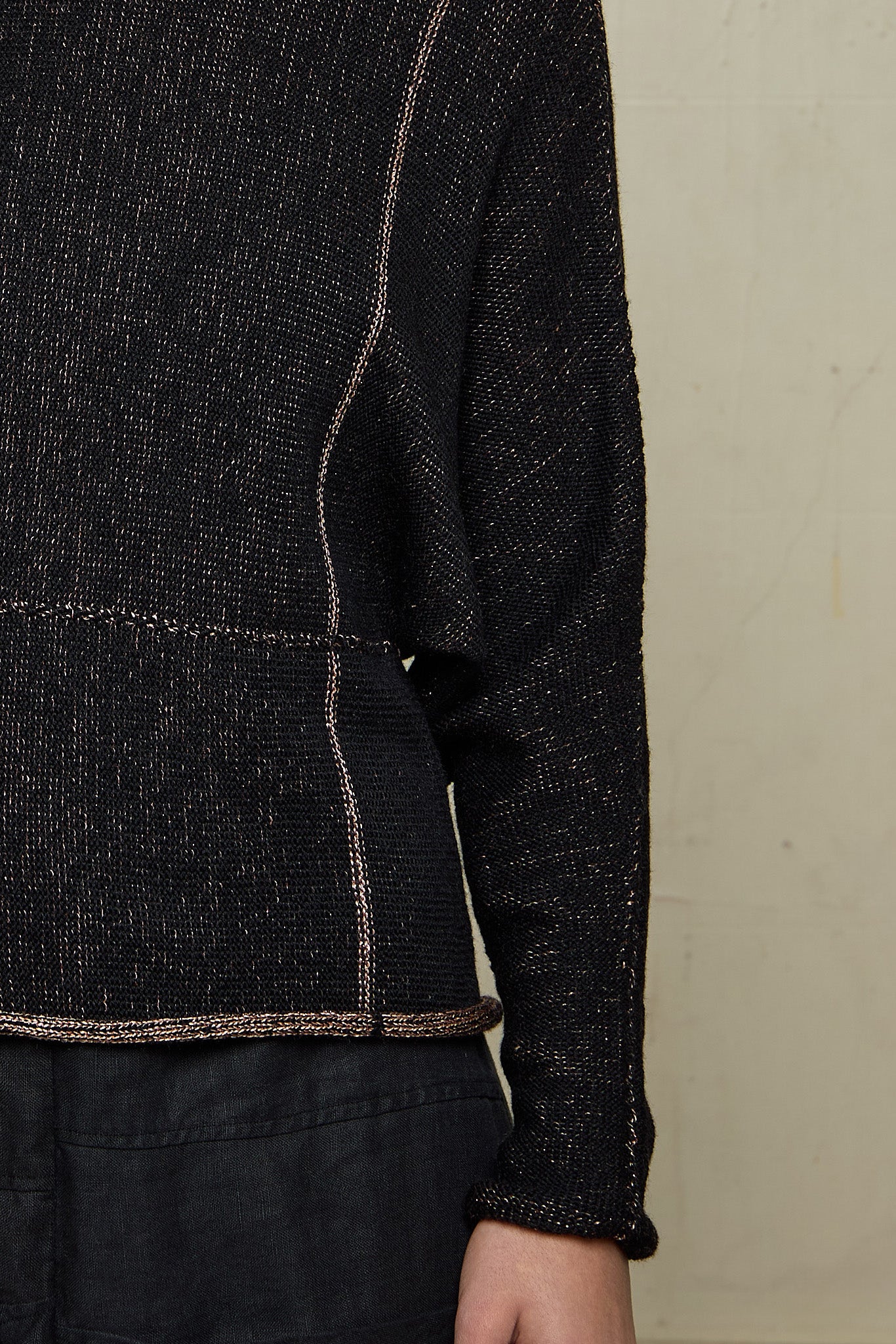 Close up view of fabric on metallic dolmain jumper with pink gold shimmering through black, designed and knitted in Melbourne by Wendy Voon knits