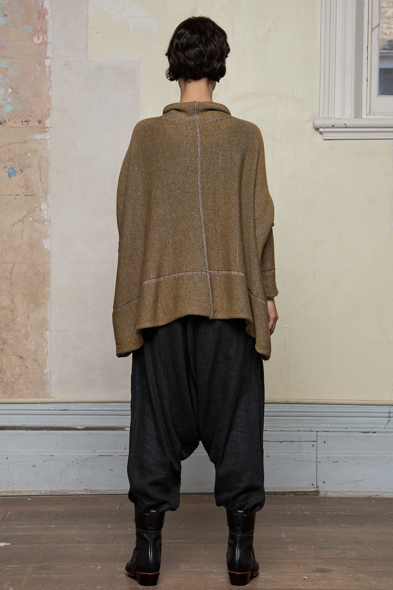 Back view of model wearing a wool boxed shaped jumper in mustard backed with grey merino wool, designed and made in Melbourne by Wendy Voon knits.