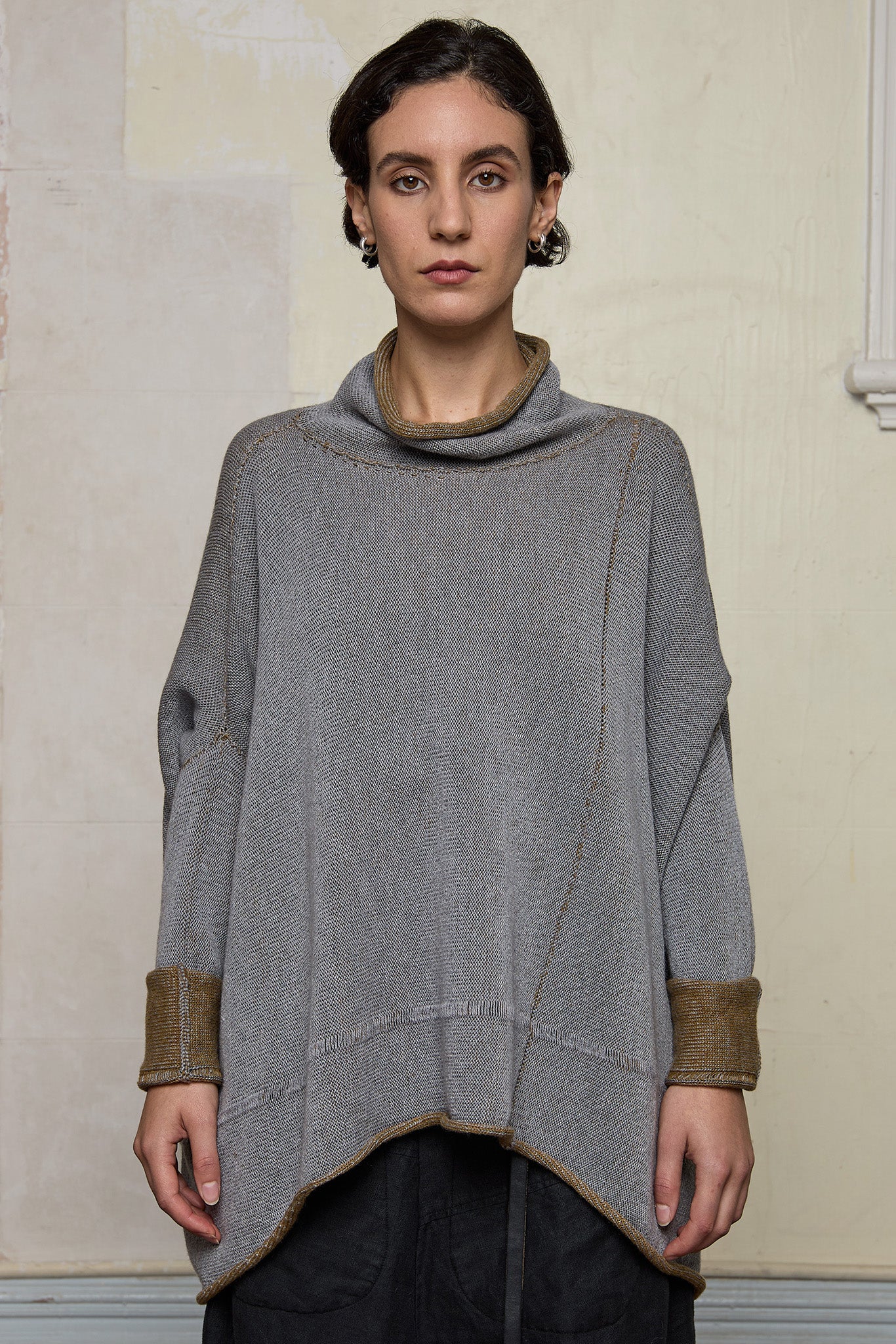 Front view of boxed jumper worn inside out, grey/blue is outside and mustard is inside.