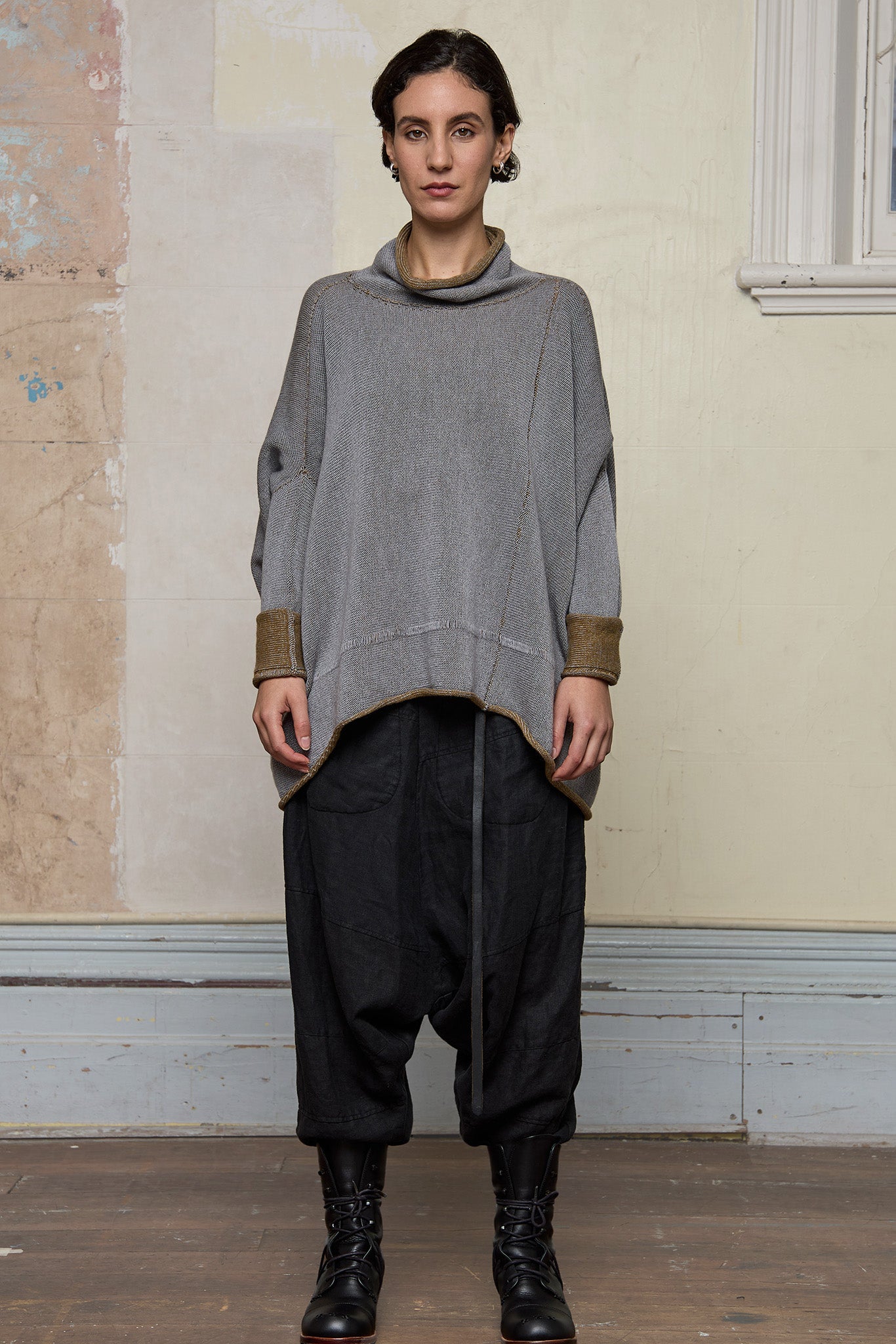 Front view of model wearing a wool boxed shaped jumper in mustard backed with grey merino wool, worn inside out. Designed and made in Melbourne by Wendy Voon knits.