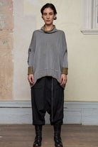 Front view of model wearing a wool boxed shaped jumper in mustard backed with grey merino wool, worn inside out. Designed and made in Melbourne by Wendy Voon knits.