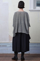 Back view of model wearing a linen/cotton tulip top in silver grey backed with black.