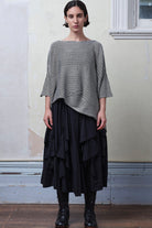 Model wears linen/cotton tulip top in silver grey backed with black.