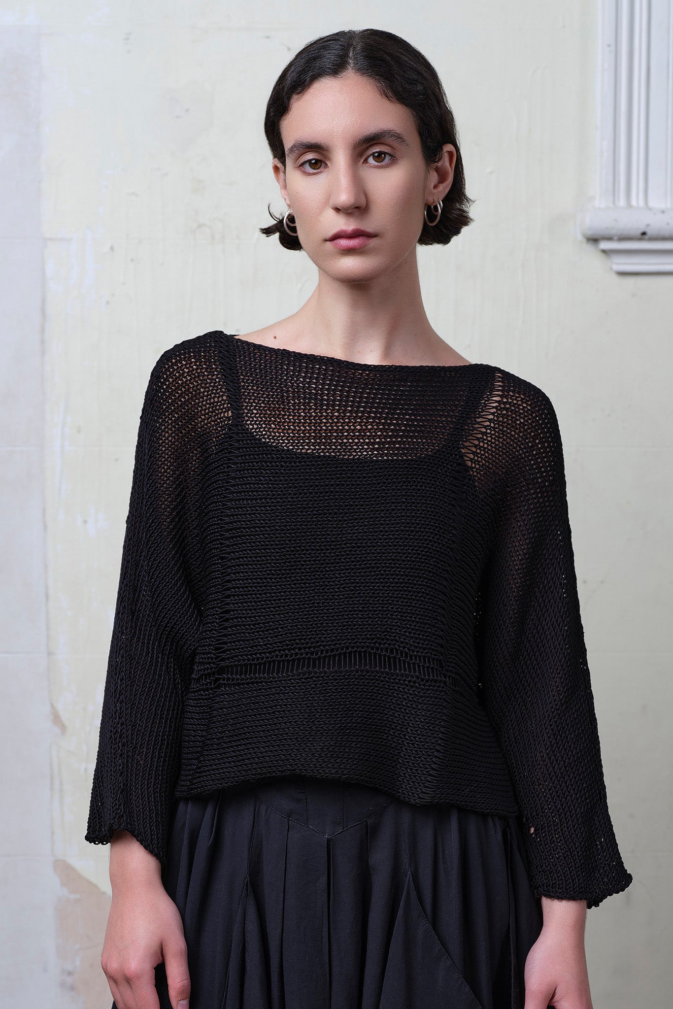 Front view of model wearing Cotton Batwing  in black colourway, featuring lace details along garment seam,  designed by Wendy Voon knits.