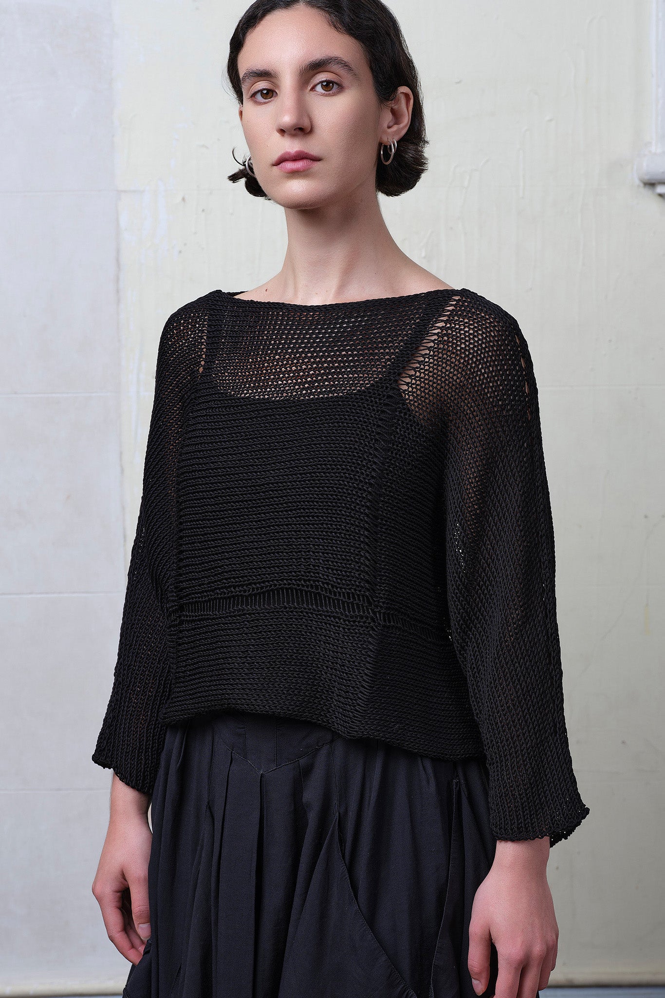 Front view of model wearing Cotton Batwing  in black colourway, featuring lace details along garment seam,  designed by Wendy Voon knits.