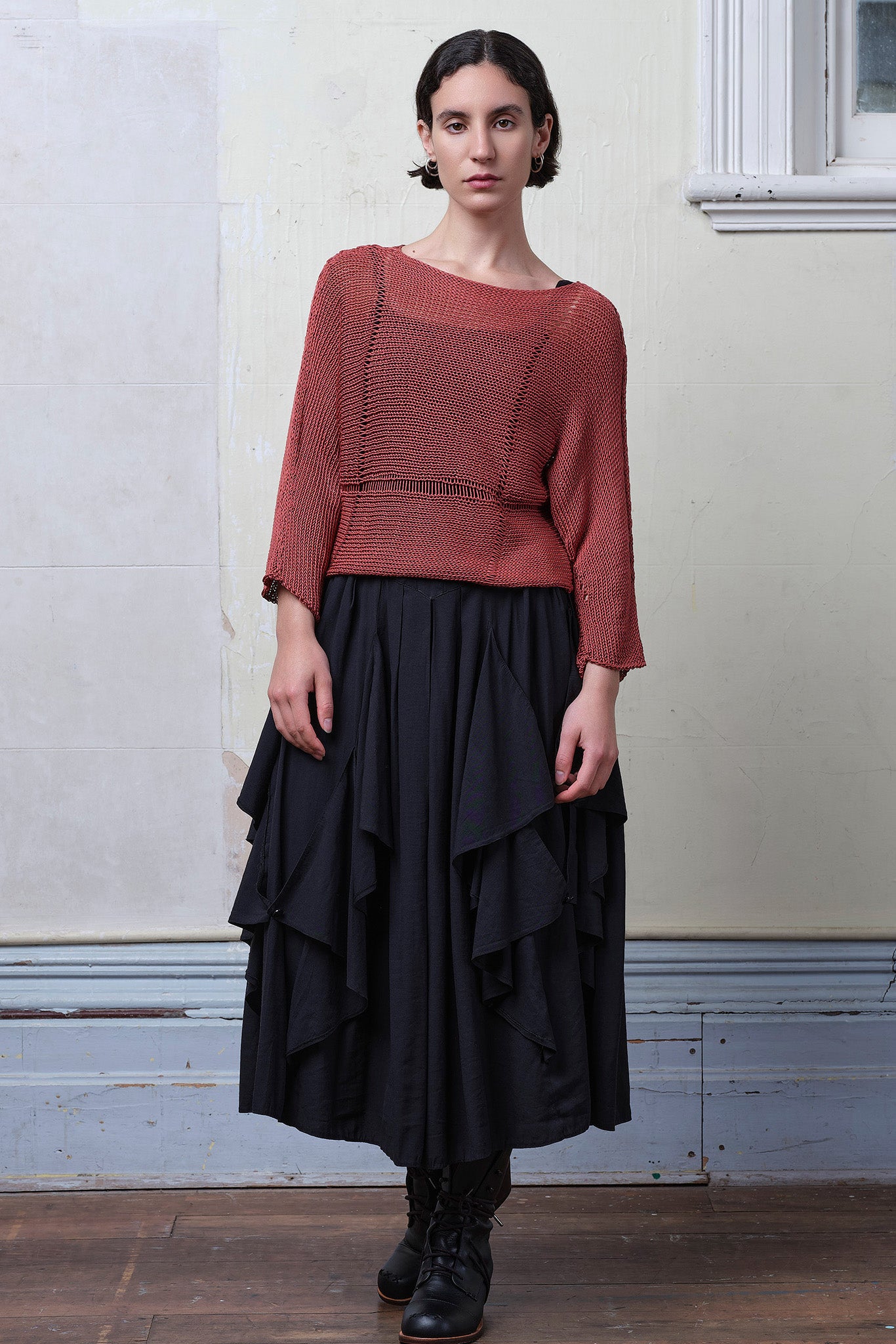 Front view of model wearing Cotton Batwing  in coral colourway, featuring large stitch details,  designed by Wendy Voon knits.