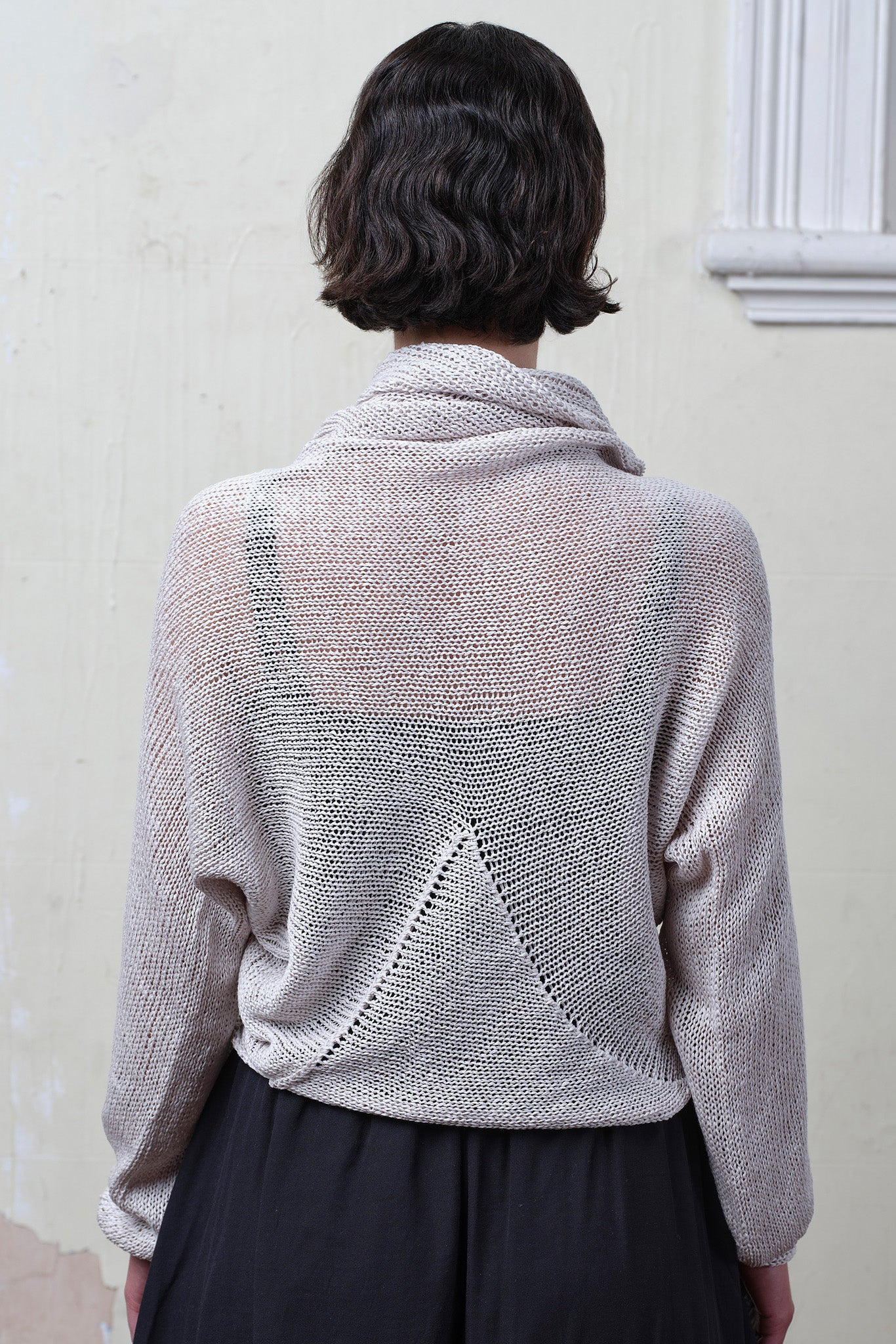 Back view of model wearing pearl coloured knitted back scoop jumper in a cotton/linen blend. Designed and knitted in Melbourne by Wendy Voon knits.