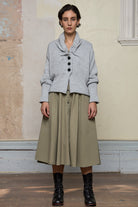 Front view of off white superfine merino wool ruched cardi, worn buttoned up.  Designed and made by Wendy Voon knits.