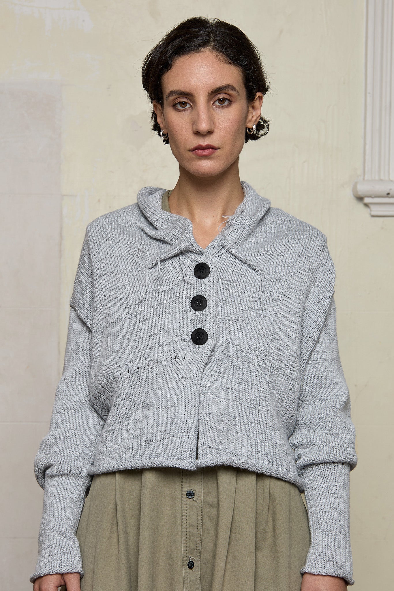 Front view of off white superfine merino wool ruched cardi, worn buttoned up.  Designed and made by Wendy Voon knits.