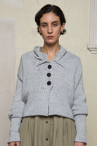 Front view of off white superfine merino wool ruched cardi, worn buttoned up.  Designed and made by Wendy Voon knits.
