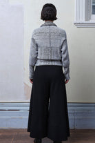 Model wears cotton and superfine merino ruched cardigan upside down in white, grey and black melange colourway.
