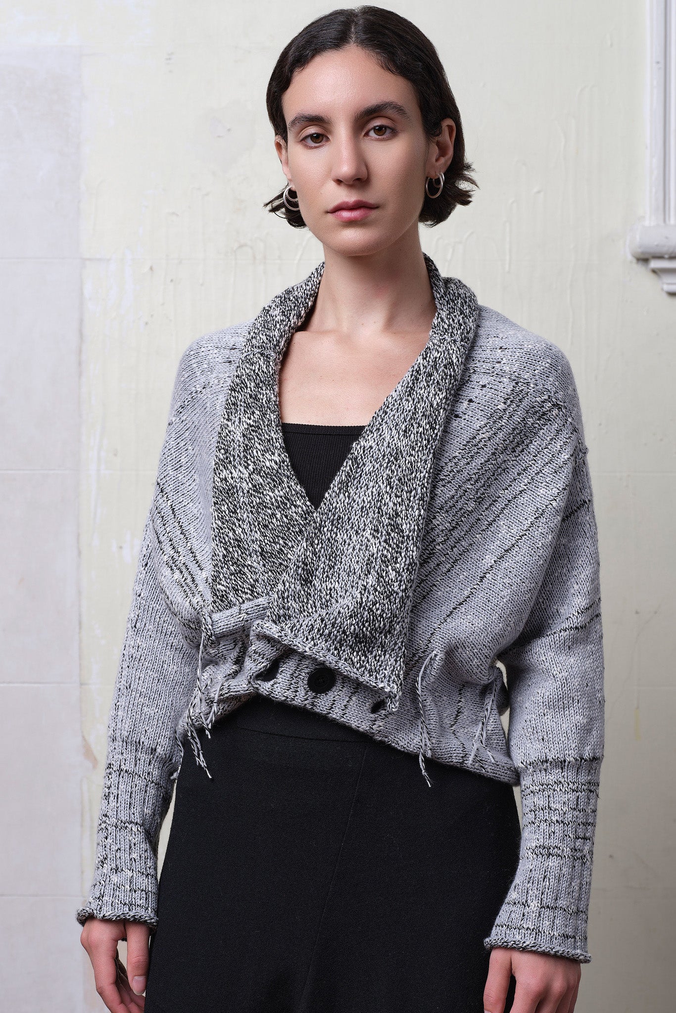 Model wears cotton and superfine merino ruched cardigan upside down in white, grey and black melange colourway.